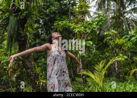 Giovane donna in abito tra foresta tropicale Foto Stock