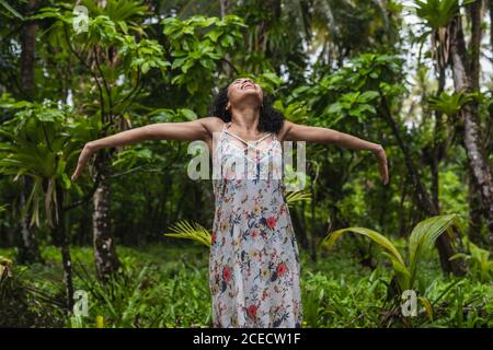 Giovane donna in abito tra foresta tropicale Foto Stock