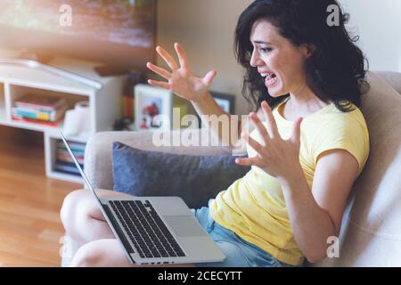 Arrabbiato infastidito donna che ha problemi con il computer, pazza donna indignata per rottura notebook guasto, perso dati importanti dopo errore critico fatale, pc Foto Stock