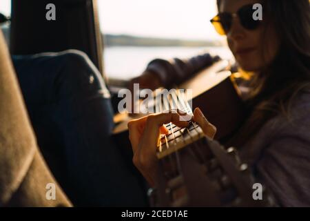 Donna con chitarra in auto in natura Foto Stock