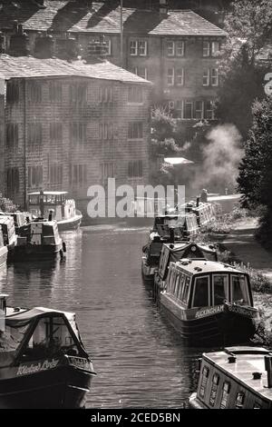 Narrwboats and weavers cottage riflesso nel canale Rochdale, Hebden Bridge, Pennines, Yorkshire Foto Stock