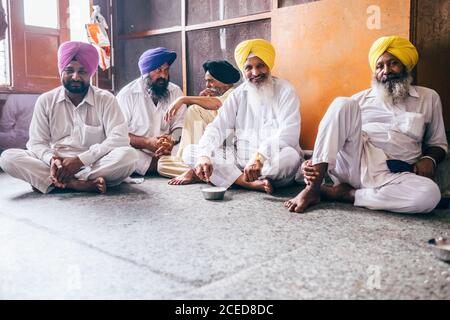 Amritsar, India – 15 agosto 2016: Sikh uomini che si siedono nella mensa libera nel Tempio d'Oro Foto Stock