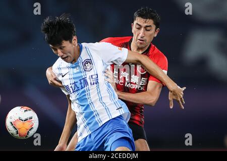 Il calciatore uzbeko Odil Ahmedov di Shanghai SIGG F.C., a destra, tenta di rubare la palla durante l'ottava partita della Super League Cinese 2020 (CSL) contro Tianjin TEDA F.C., città di Suzhou, provincia di Jiangsu della Cina orientale, 31 agosto 2020. Shanghai SIGG F.C. sconfisse Tianjin TEDA F.C. con 4-1. Foto Stock