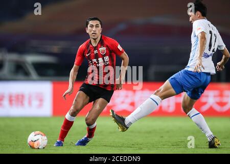 Il calciatore uzbeko Odil Ahmedov di Shanghai SIGG F.C., a sinistra, protegge la palla durante l'ottava partita della Super League Cinese 2020 (CSL) contro Tianjin TEDA F.C., città di Suzhou, provincia di Jiangsu, nella Cina orientale, il 31 agosto 2020. Shanghai SIGG F.C. sconfisse Tianjin TEDA F.C. con 4-1. Foto Stock