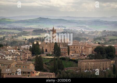 La Basilica di San Clemente a Santa Maria dei Servi circondata dal paesaggio toscano, Siena, Italia. Foto Stock