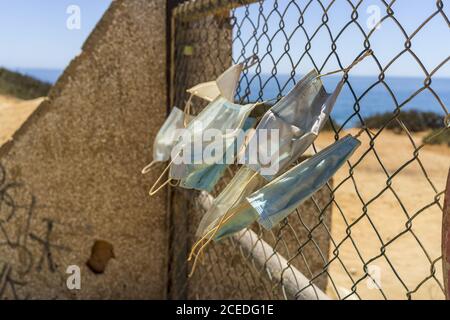 Foto closeup di maschere di faccia appese su una recinzione Foto Stock