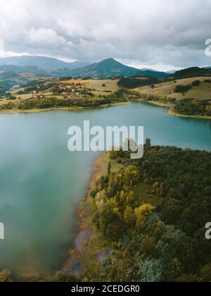 Vista aerea della foresta verde sul lago blu e piccolo villaggio in collina a Pais Vasco, Paesi Baschi, Spagna Foto Stock