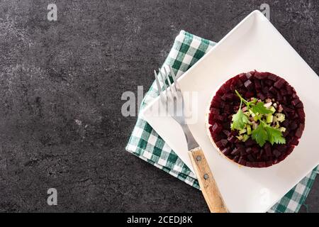 Insalata tradizionale russa di aringhe con barbabietole e carote su nero sfondo Foto Stock