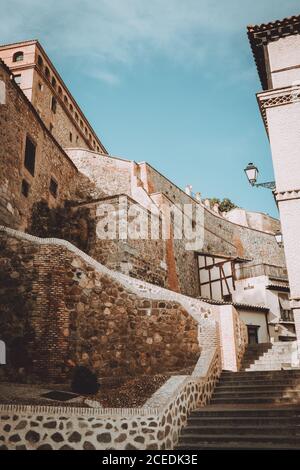 Maestosa vista della scalinata e degli antichi edifici in pietra sulla strada Di Toledo in giornata di sole in Spagna Foto Stock