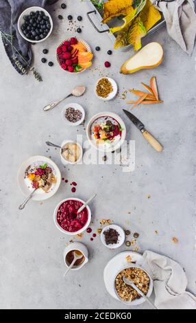 Dall'alto, un delizioso parfait di chia e frutta varia e graniglia giacente sul piano di marmo Foto Stock