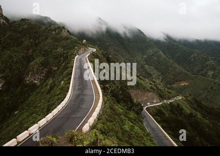 Due strade asfaltate attraversando montagna cresta sulla splendida nebbioso giorno nel maestoso paesaggio Foto Stock