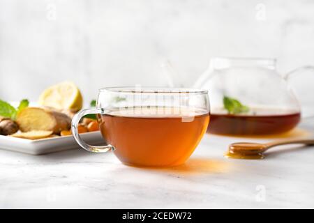 Tazza di tè al limone, miele, curcuma e zenzero su sfondo bianco Foto Stock