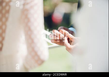 Giovane uomo e donna scambiano gli anelli di nozze in giardino Foto Stock