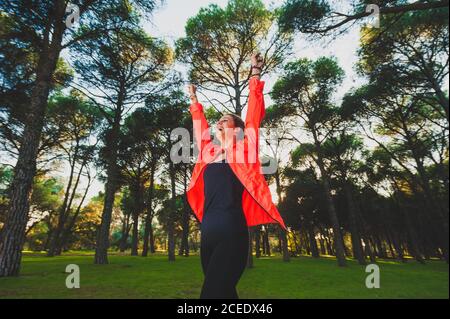 Entusiasta sportswoman con le braccia sollevate nel parco Foto Stock