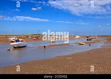 Le barche si sono arenate sul Creek a bassa marea a Brancaster Staithe, Norfolk, Regno Unito Foto Stock