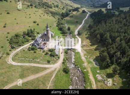 Drone vista del bellissimo paesaggio con la chiesa sul torrente circondato da verde foresta, Asturie Foto Stock