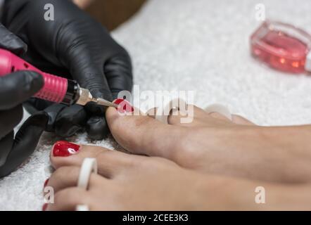 centro di manicure e pedicure dove c'è una signora dipingere i chiodi delle mani e dei piedi Foto Stock