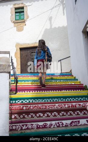 Donna che cammina su scale colorate Foto Stock
