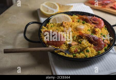 Paella marinera, piatto tipico della cucina spagnola, composto da riso, gamberi, calamari e cozze Foto Stock