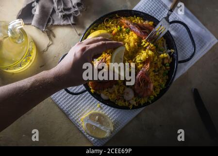 Paella marinera, piatto tipico della cucina spagnola, composto da riso, gamberi, calamari e cozze Foto Stock