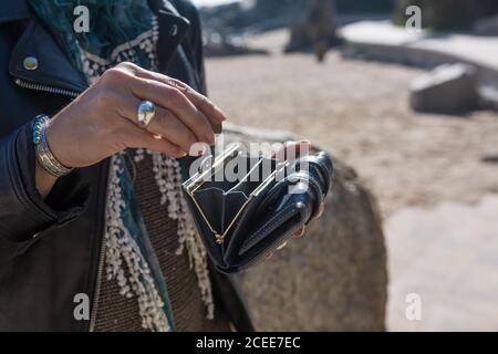 Donna che usa la sua borsa e il suo moderno zaino per portare il suo smartphone. Foto Stock