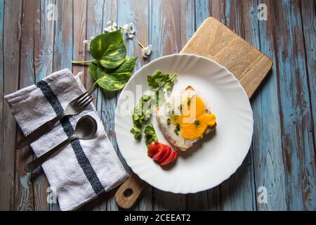 Uova e pane con condimenti su un piatto di legno Foto Stock