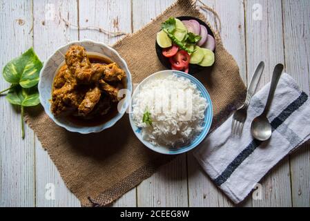 Vista dall'alto del curry di pollo, del riso e degli ingredienti per insalate, una famosa prelibatezza indiana Foto Stock