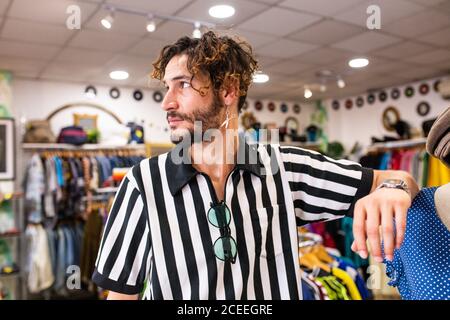 Uomo allegro in negozio guardando via Foto Stock