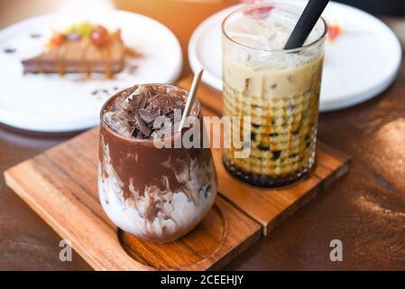 Bevanda di cacao cioccolato e tè al latte di Bubble o latte di Taiwan tè in vetro sul tavolo di legno con torta Foto Stock