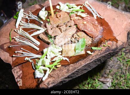 Cibo su pietra / shabu shabu carne di maiale alla griglia e verdure e funghi su piatto di pietra calda, sopravvivenza nel concetto selvaggio Foto Stock