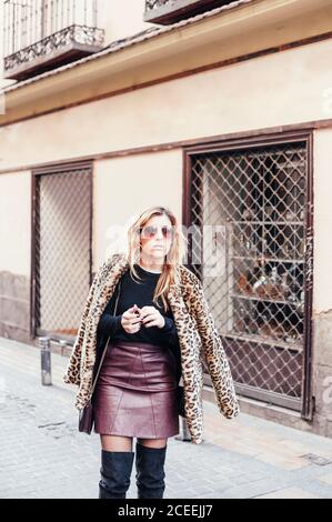 Ritratto di giovane bionda Donna con gonna in pelle nelle strade di madrid, Spagna Foto Stock