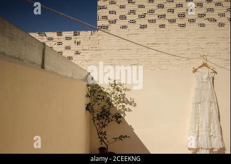 Vista su un abito da sposa appeso a una lampada Foto Stock