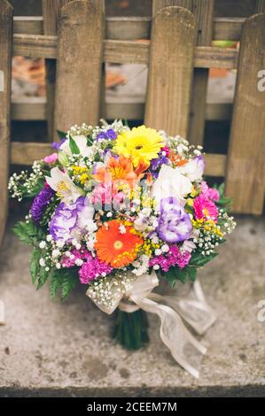 Mazzo di fiori colorati diversi sul tavolo e bicicletta sportiva al chiuso. Foto Stock
