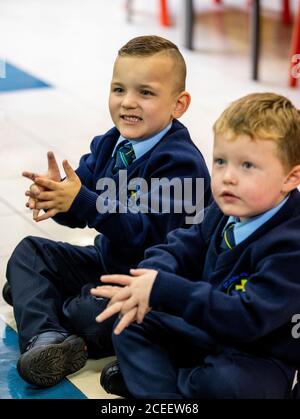 Leo di Vecsi (a sinistra) e Oisin Hicks mimano lavarsi le mani mentre guardano il Baby Shark Hand Wash Challenge il primo giorno di P1 alla St John the Baptist Primary School a Belfast ovest, Poiché quasi tutte le scuole si sono riaperte e oltre 300,000 studenti sono tornati a scuola in Irlanda del Nord per la prima volta da metà marzo. Foto Stock