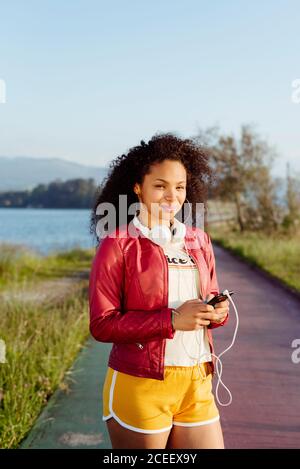 Donna afroamericana con smartphone in campagna Foto Stock