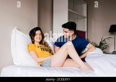 Sorridente coppia giacendo in letto Foto Stock