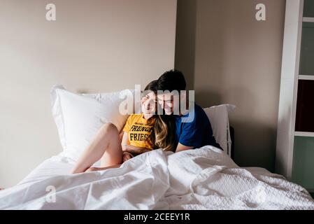 Sorridente coppia giacendo in letto Foto Stock
