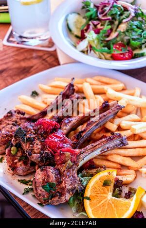 Costolette di agnello alla griglia con patatine fritte e insalata Foto Stock