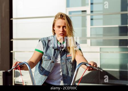 Attraente giovane donna seduta su una bicicletta d'epoca Foto Stock