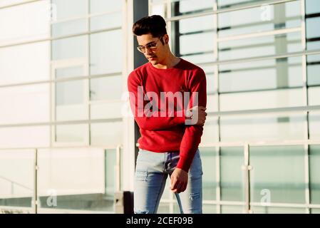 Attraente giovane uomo in piedi in città Foto Stock