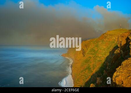 Fumo dalla foresta che brucia sull'oceano. Isola di Madeira, Portogallo Foto Stock