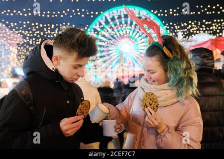 Ritratto di Natale invernale di felice adolescente ragazzo e ragazza a. mercato delle vacanze Foto Stock