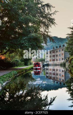 Narrowboat e tessitori cottage riflessi nel canale Rochdale, Hebden Bridge, Pennines, Yorkshire Foto Stock