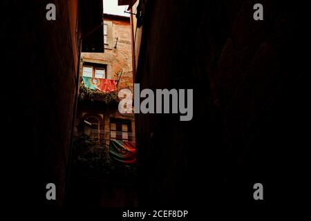 Due bandiere del Portogallo appeso sulla facciata del vecchio edificio sulla stretta strada scura in porto Foto Stock