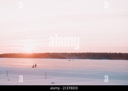 Persone che cavalcano motoslitte sul lago ghiacciato Foto Stock