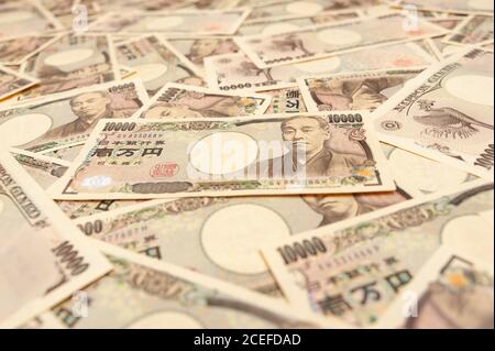 10,000 Yen Nota - sfondo con vista prospettica di varie banconote da diecimila yen (fronte). Denaro giapponese. Concetto: Abbondanza finanziaria. Foto Stock