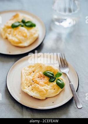 Uova di nuvola soffici. Cibo alla moda - forno cuocere uova strapazzate con albume d'uovo montato e tuorlo intero sul piatto verticale. Foto Stock