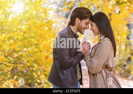 Coppia in amore tenendo le mani e toccandosi fronte Foto Stock