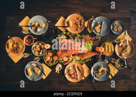 Top sopra foto ad alto angolo di grande arrosto cotto farcito insalata di tacchino decorazione metà della cena grazie pasto dio pieno i piatti guarnire il tovagliolo giallo due candele Foto Stock