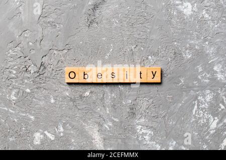 Parola di obesità scritta su blocco di legno. Testo di obesità sulla tabella del cemento per il vostro desing, concetto. Foto Stock